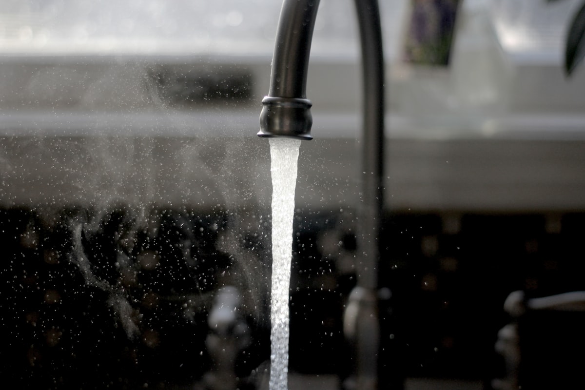 A kitchen faucet running water into a sink